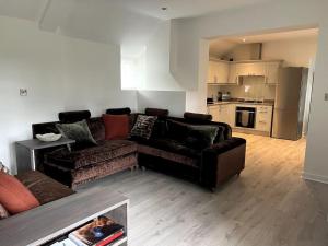 a living room with a couch and a kitchen at Woodhouse Retreat in Woodhouse
