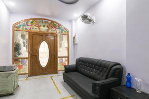 a living room with a couch and a wooden door at Super OYO Capital O 78105 Hotel Figtree Premier in Patna