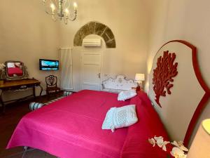 um quarto com uma cama grande e uma colcha rosa em Corallo Suite em Pisa