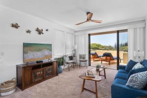 a living room with a blue couch and a tv at Kapalua Golf Villas 15T5 in Kahana