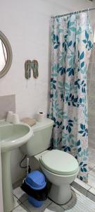 a bathroom with a toilet and a shower curtain at Alta Vibra Appartement in Sámara