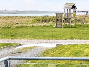 a playground in a field next to a field of grass at 4 person holiday home in Harbo re in Harboør