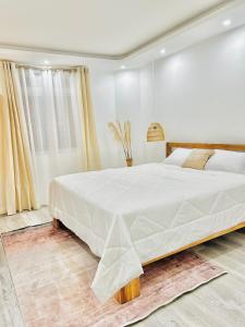 a bedroom with a large white bed in a room at Vans Haven in Curepipe