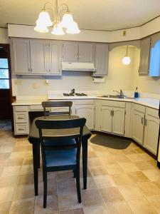 a kitchen with white cabinets and a table and chairs at 2BR Erie Flat Near Gannon & Mercyhurst in Erie