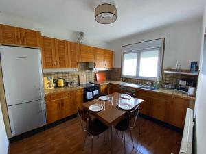 a kitchen with a table and a white refrigerator at Comme à la maison in La Roche-sur-Yon