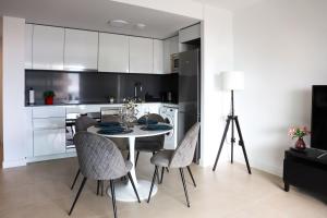 een keuken met een tafel en stoelen in een kamer bij Apartamento de lujo Alexia 1 Calpe in Calpe