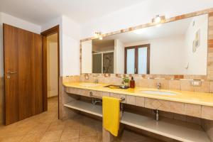 a bathroom with two sinks and a large mirror at VILLE MONDO a 350 metri dalla spiaggia in Àrbatax +96 photos