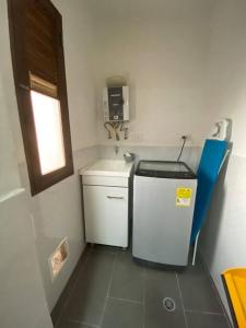 a small kitchen with a sink and a small refrigerator at Aldea Comercial Condominio Ruitoque Golf in Floridablanca