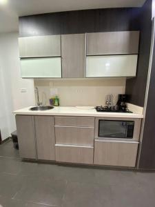 a kitchen with a sink and a microwave at Aldea Comercial Condominio Ruitoque Golf in Floridablanca