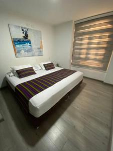 a large bed in a room with avertisement at Aldea Comercial Condominio Ruitoque Golf in Floridablanca