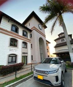 a car parked in front of a building with a clock at Aldea Comercial Condominio Ruitoque Golf in Floridablanca