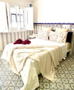 um quarto com uma grande cama branca com almofadas vermelhas em Zenit charm Olhao relax cubist House em Olhão