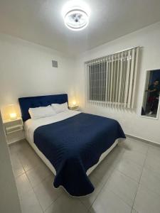 a bedroom with a large bed with a blue blanket at Acapulco Dreamer Diamante II in Gallinero