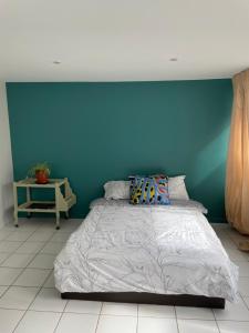 een bed in een kamer met een blauwe muur bij Rooms with garden in Luckyhouse Maison Chatou Paris La Défense in Chatou