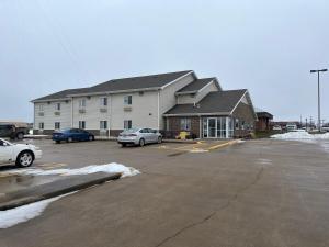Un estacionamiento con autos estacionados frente a un edificio. en Country Haven Inn, en Burlington