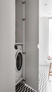 a laundry room with a washing machine in a door at Modern Apartment for a great stay in Helsinki