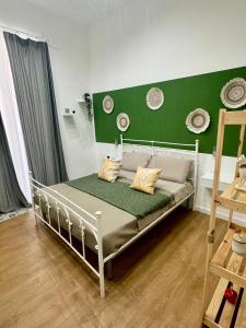 a bed in a room with a green wall at San marco 56 in Bari