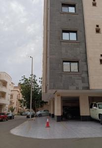 a building with a parking lot with cars parked at شقة مفروشة فاخرة جدة حي الروضة, دخول ذاتي in Jeddah
