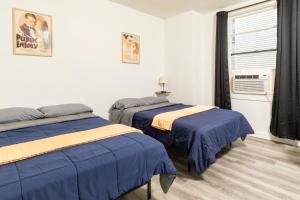 a bedroom with two beds and a window with a fan at Port Huron Temp Stays - Apartment 5 in Port Huron +6 photos