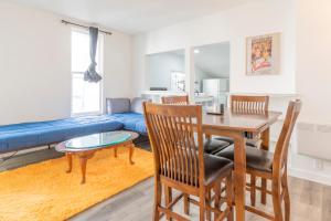 een woonkamer met een tafel en stoelen en een bank bij Port Huron Temp Stays - Apartment 5 in Port Huron