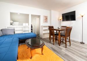 een woonkamer met een blauwe bank en een tafel bij Port Huron Temp Stays - Apartment 5 in Port Huron
