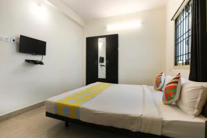 a bedroom with a large bed with a tv on the wall at OYO Home Harma Residency Near Koyambedu Metro Station in Chennai