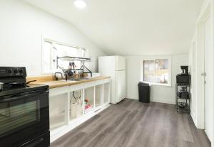 een keuken met witte kasten en een zwarte kachel bij Port Huron Temp Stays - Apartment 5 in Port Huron
