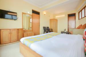 ein Schlafzimmer mit einem großen Bett und einem TV in der Unterkunft OYO Home 78009 Avon Villa Kanlog in Shimla