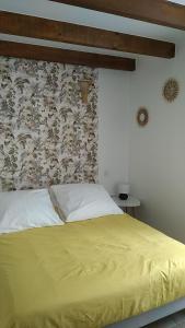 sypialnia z łóżkiem z żółtą narzutą w obiekcie Le triplex Saint Aphrodise, terrasse au calme w Béziers