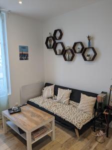 a living room with a couch and a table at Cosy appartement / stade de France / portes paris in Saint-Denis