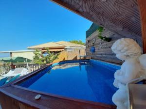 a pool with a statue next to a building at Villa Nigel (5min from Navagio) in Áno Volímai