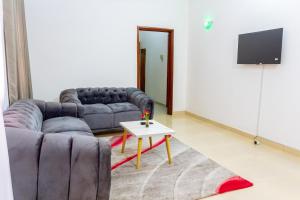 sala de estar con sofá y mesa en JRéside Appart M 40m2 centre-ville, en Cotonou