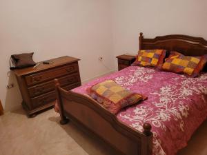 1 dormitorio con cama de madera y vestidor en Studio raoued plage en Borj el Khessous