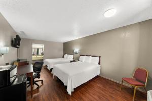 Cette chambre comprend deux lits et un bureau. dans l'établissement Americas Best Value Inn Bonham, à Bonham