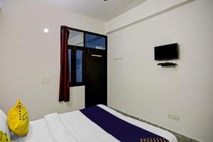 a bedroom with a bed and a window and a tv at SPOT ON Raj Hotel Vip Near Worlds Of Wonder in Kalkaji Devi