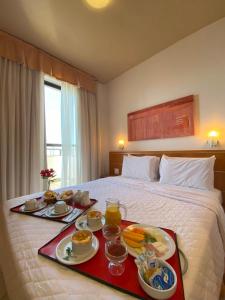una habitación de hotel con una bandeja de comida en una cama en Differential Flat, en Belo Horizonte