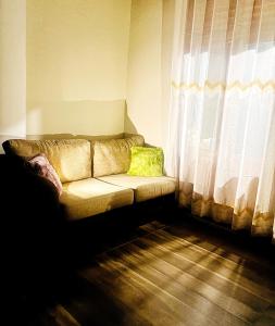 a couch sitting in a room with a window at Serene Stay in Kurunegala