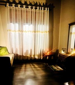 a living room with a large window with curtains at Serene Stay in Kurunegala