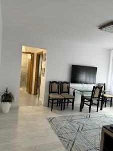 a living room with chairs and a table and a tv at Apartament Central in Râmnicu Vâlcea