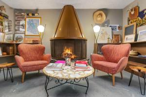 a living room with two chairs and a fireplace at Papago Motor Hotel in Scottsdale