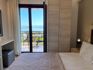 a bedroom with a bed and a door with a balcony at Panorama Dream studios A in Vourvourou