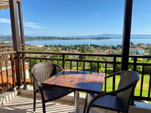 a table and chairs on a balcony with a view of the water at Panorama Dream studios A in Vourvourou