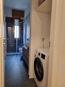 een badkamer met een wasmachine en droger in de kamer bij Massi’s House in Milaan