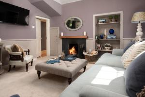 a living room with a couch and a fireplace at Wood Cottage in Coldstream