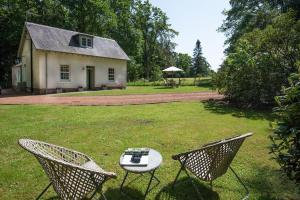 a table and chairs in a yard with a house at Wood Cottage in Coldstream