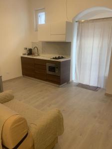 a living room with a couch and a kitchen at AngelHome Matera in Matera