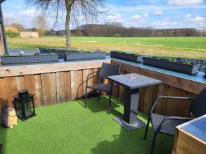 eine Terrasse mit Tisch und Stühlen auf einem Zaun in der Unterkunft Ferienwohnung Emira in Wittingen