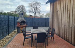 a patio with a table and chairs and a grill at Ferienwohnung Emira in Wittingen