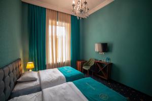 una camera d'albergo con letto e lampadario a braccio di Belona Hotel a Kutaisi