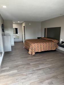 a hotel room with a bed and wooden floors at Nola Inn & Suites in New Orleans